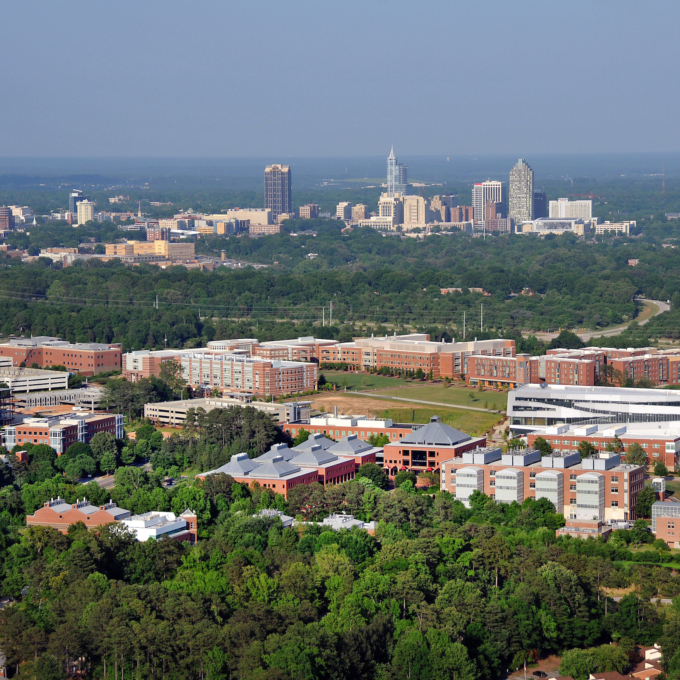 Aerial view of Centennial Campus, with the campus in the foreground, and downtown Raleigh in the distant background.