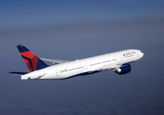A zoomed in image of a Delta airliner mid-flight at high altitude.