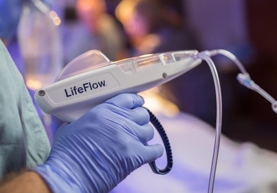 A pair of medical gloved hands holding a LifeFlow device.