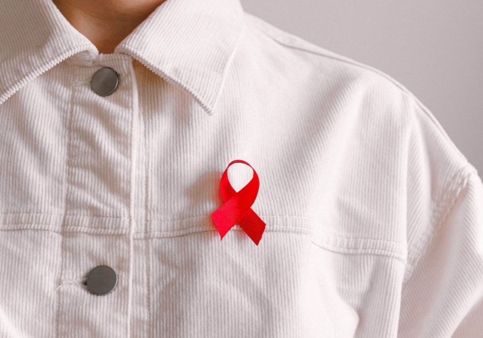A white buttoned-down collared shirt with a red AIDS ribbon to show support.